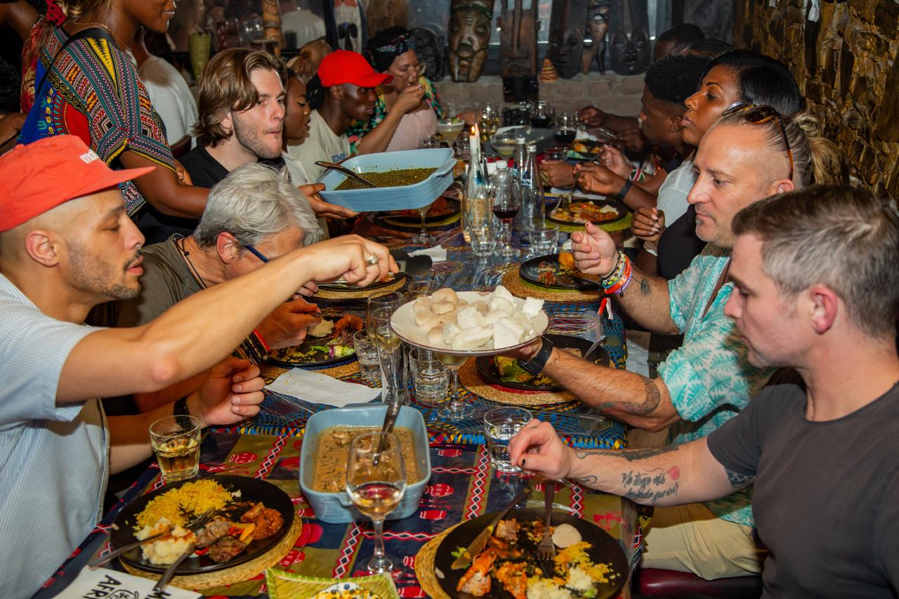 Guests sharing a vibrant African feast around a long table at Mama Africa