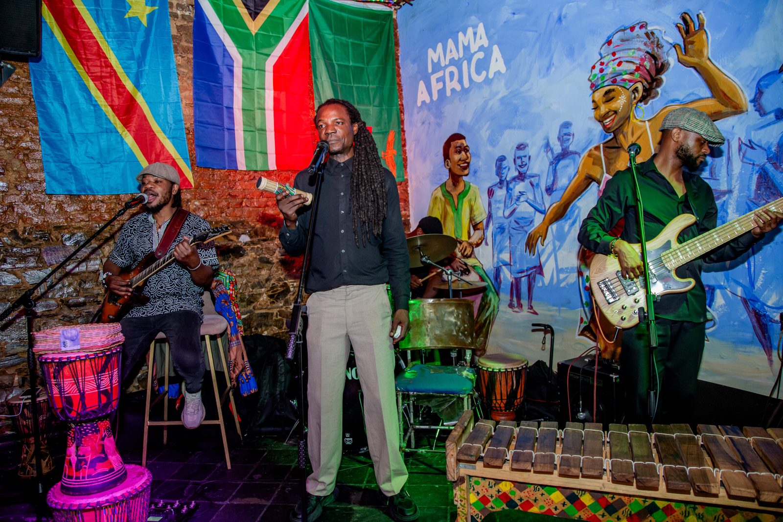 Live band performing in front of the Mama Africa mural