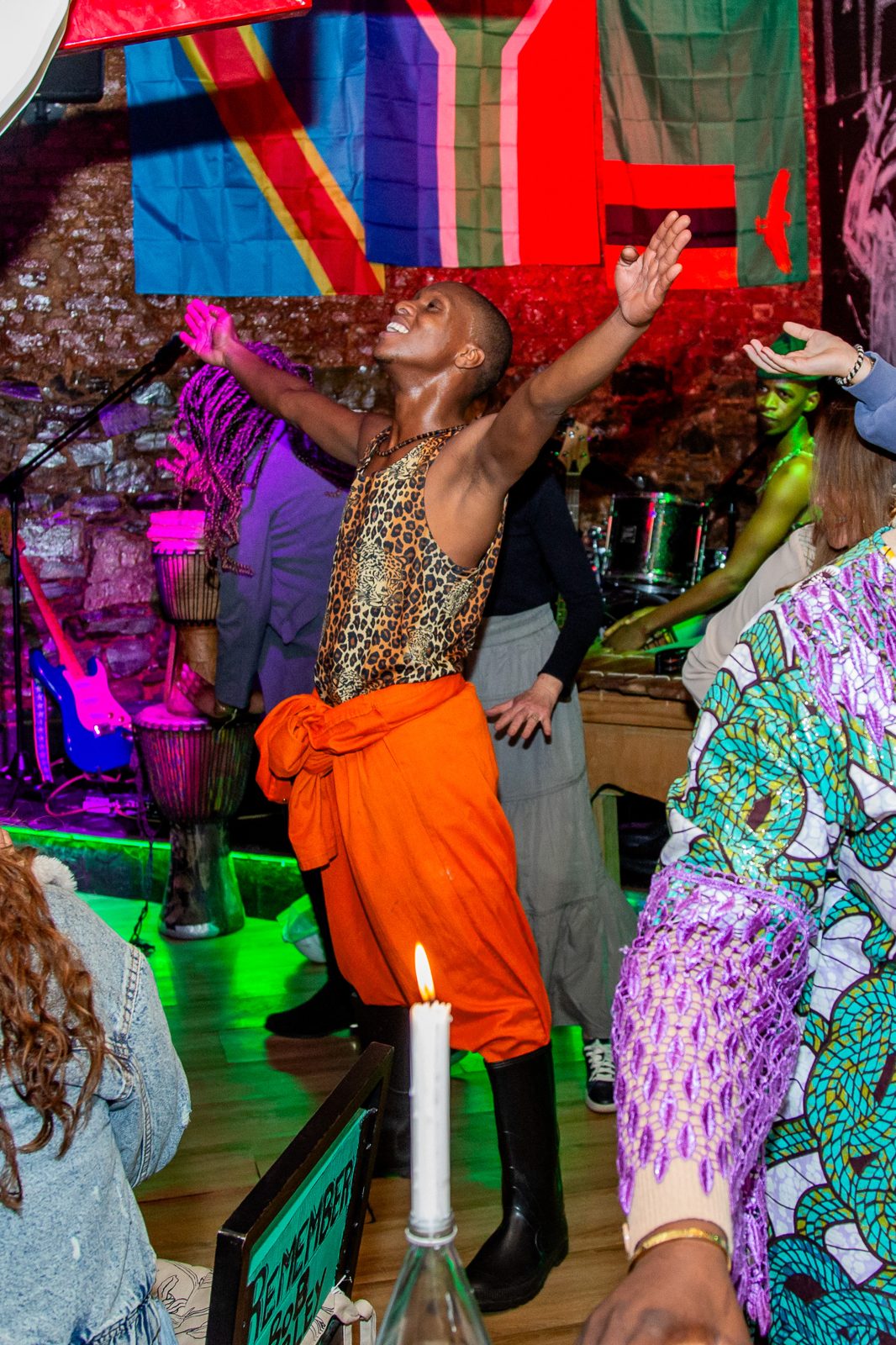 Dancer in bright costume performing under stage lights