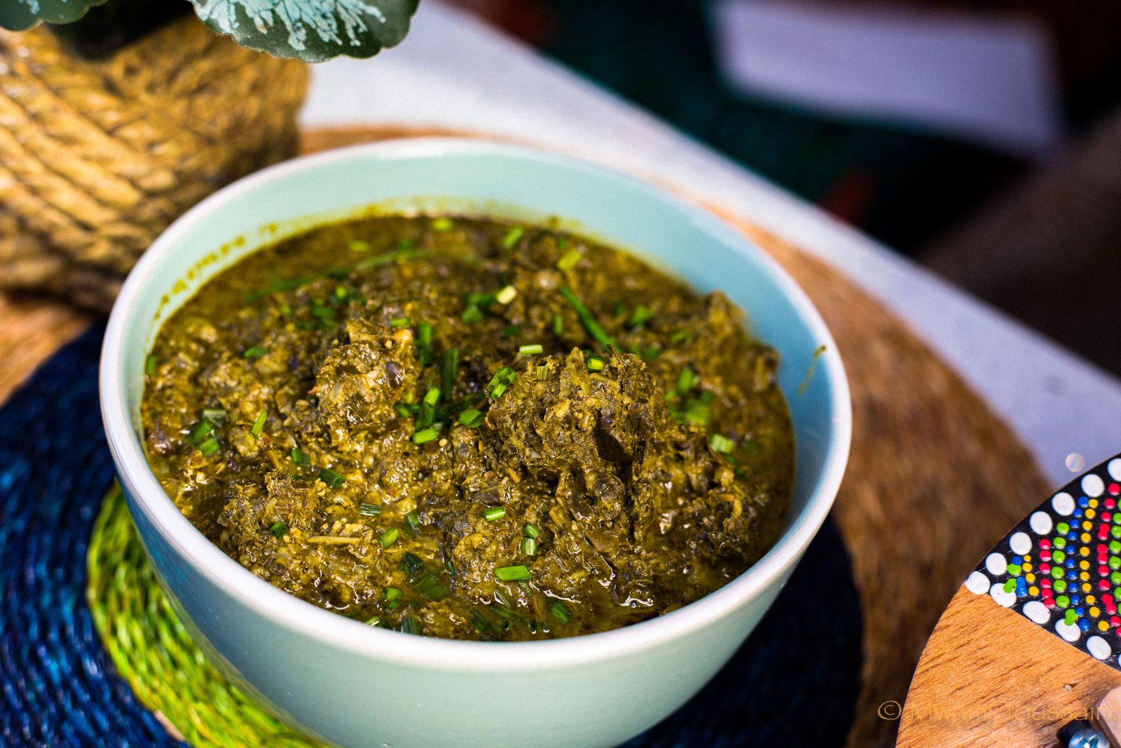 A bowl of egusi soup with bitter leaves and spinach