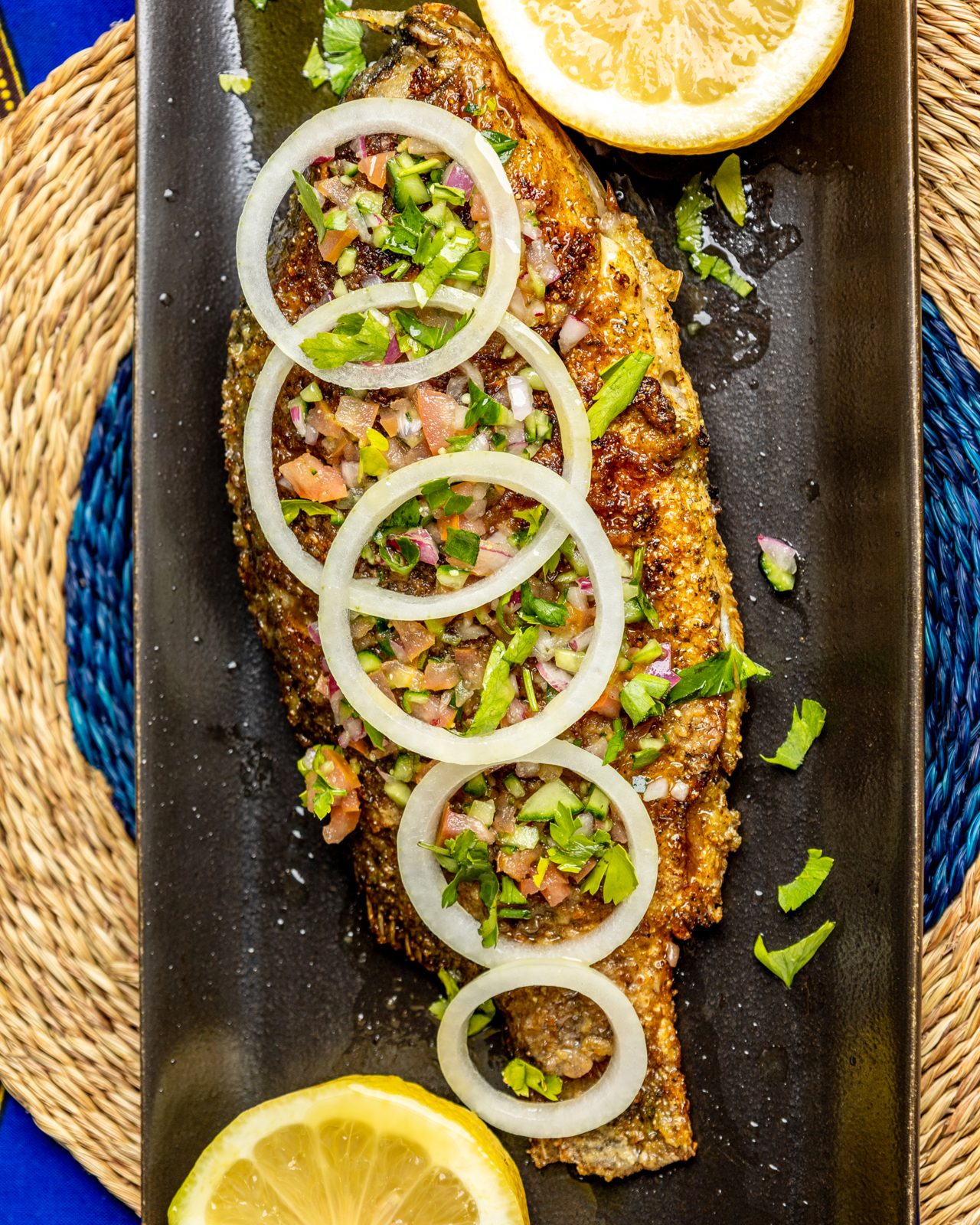 Grilled whole fish with onion rings and lemon
